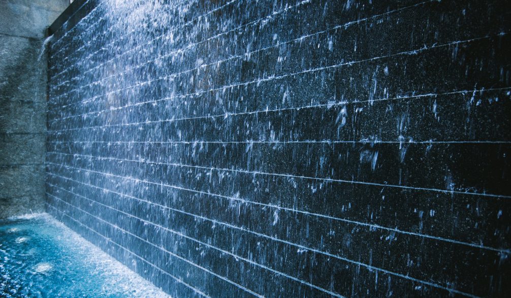Dark tile water wall with a sheer curtain of water