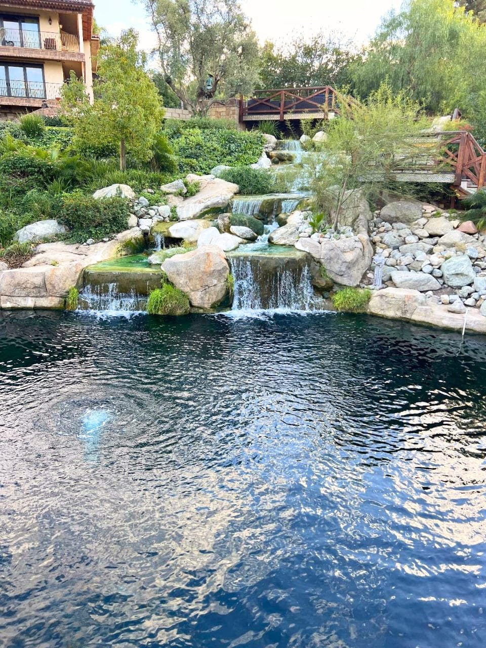Hillside cascade and bridges feeding an estate lake with aeration