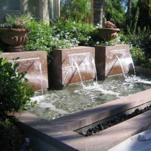 Formal fountain with three spouts into a raised basin