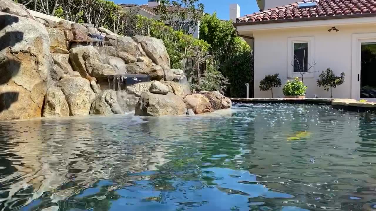 Raised estate koi pond with boulder waterfall in Laguna Beach