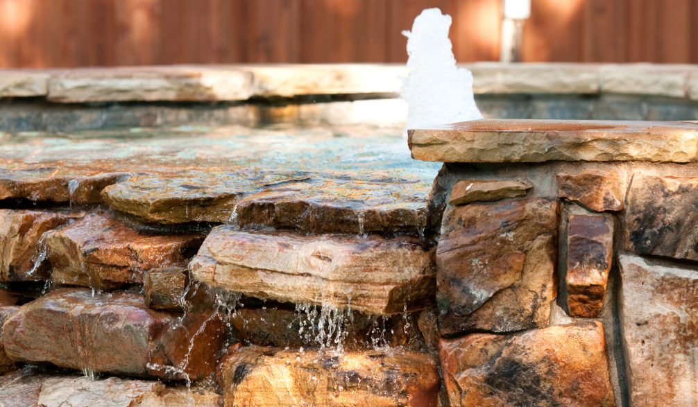 Stacked stone spillway with a bubbler on a raised feature