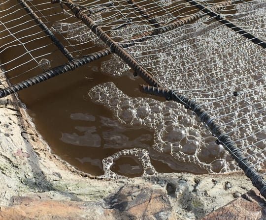 Rebar pond shell with groundwater pooling before shotcrete