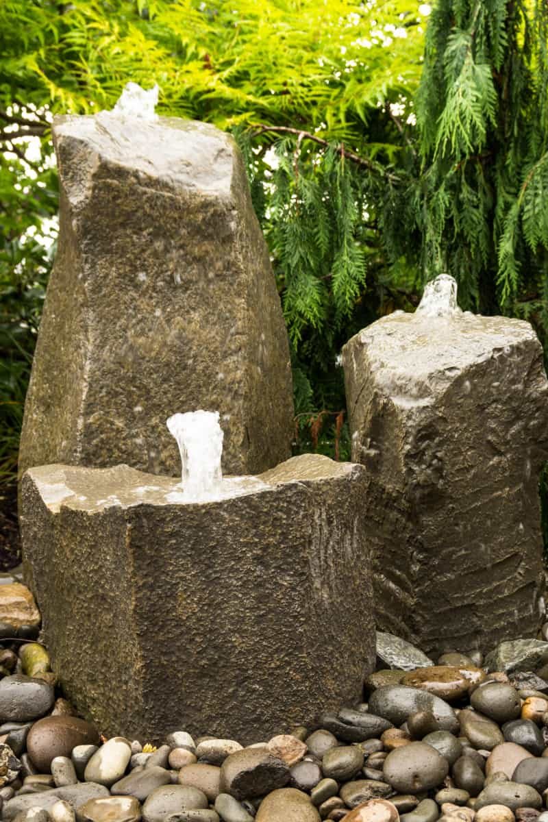 Three basalt column bubbling fountains over river rock